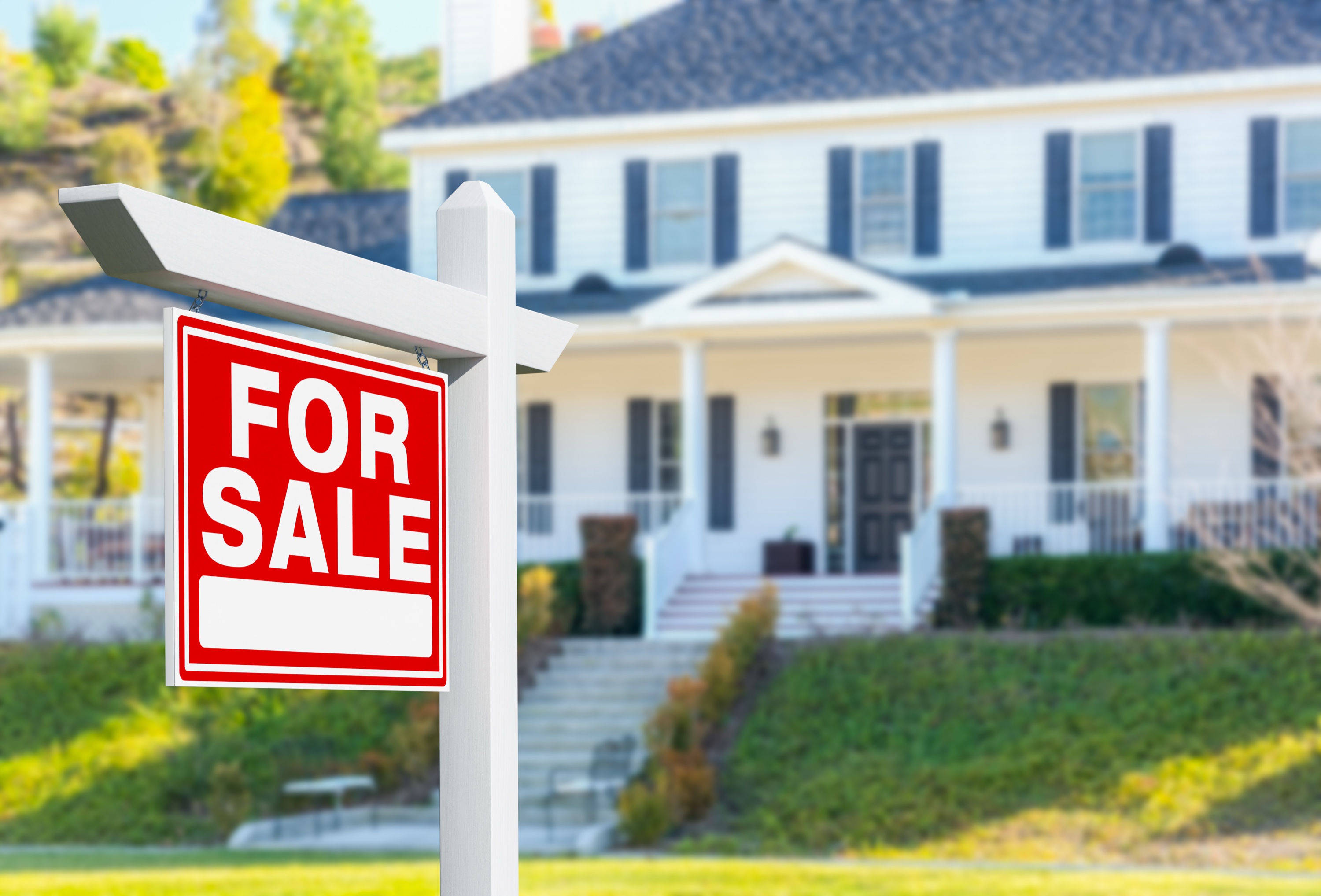 For sale sign in front of a well-kept single-family home listed in the fall market