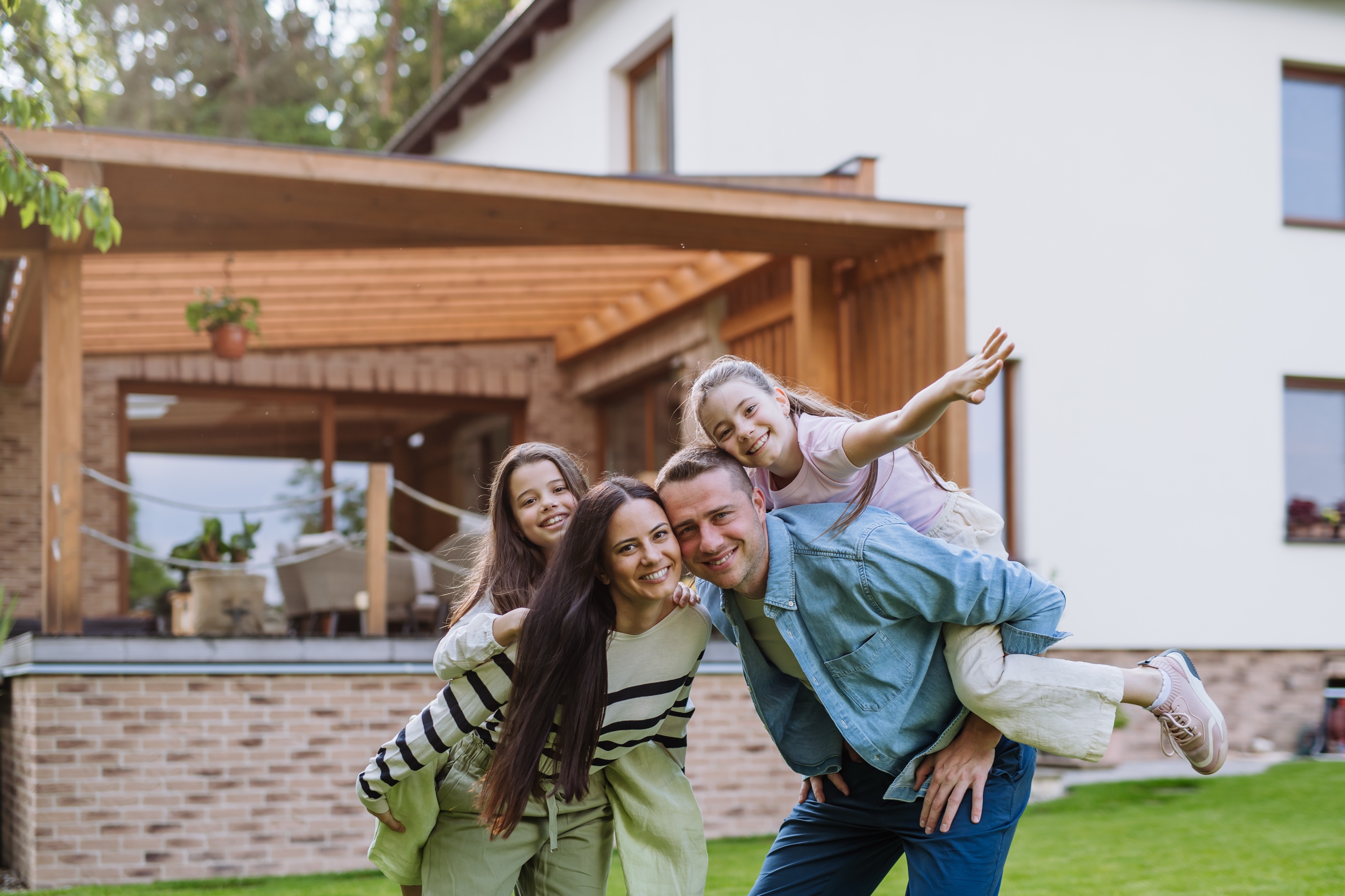 A young family standing in front of their Peninsula family home