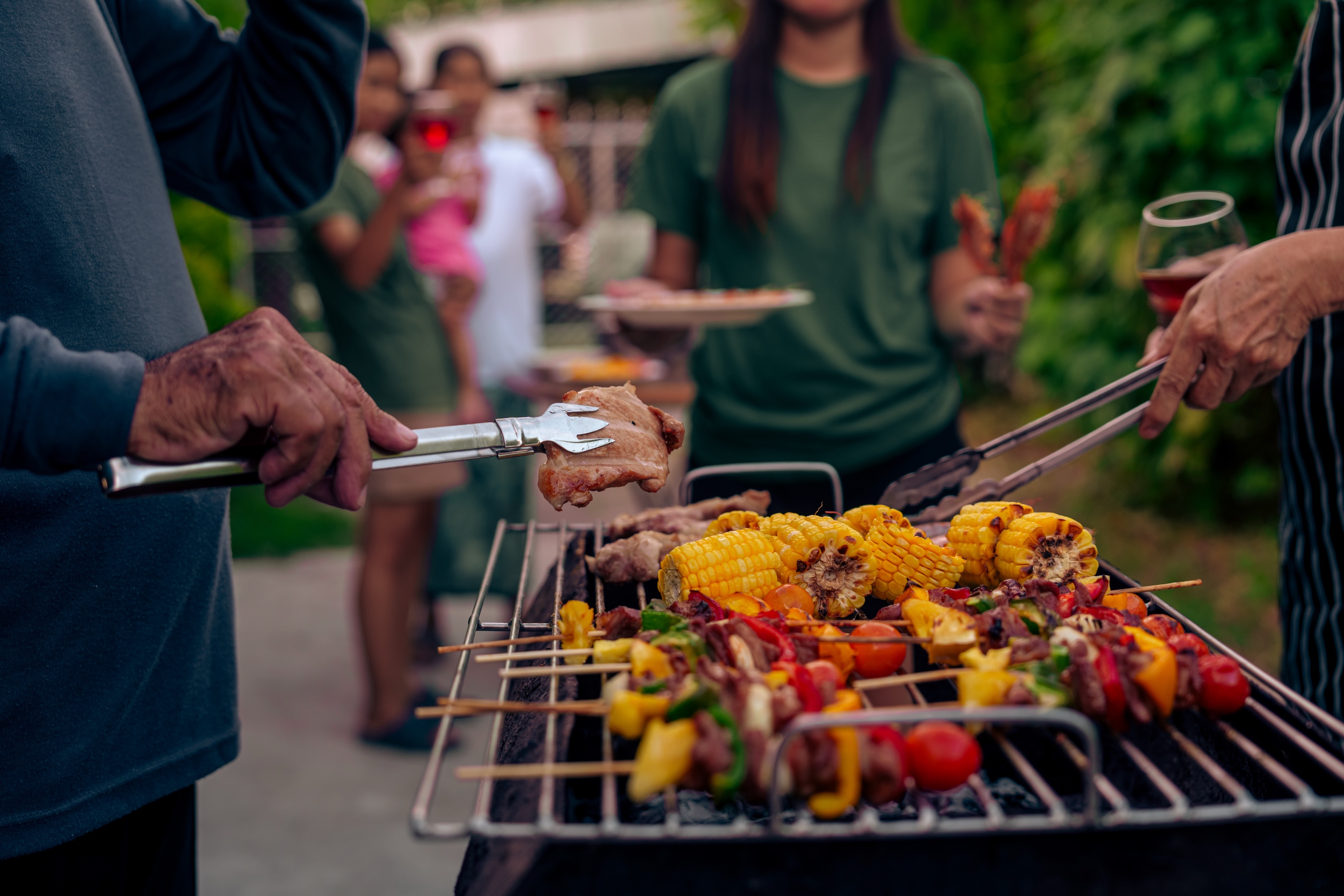 Family gathered for a summer barbecue in a backyard garden