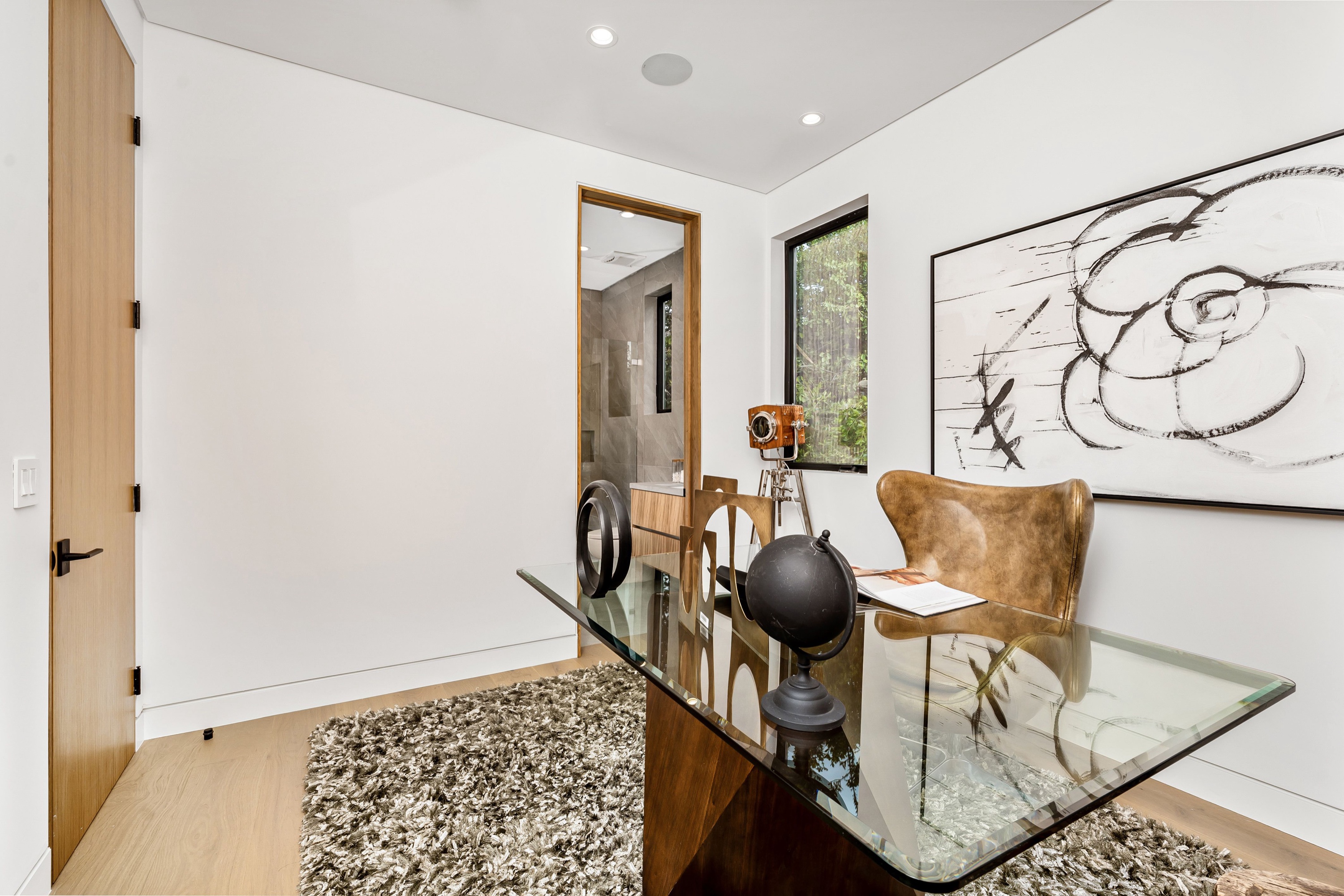 Modern home office with a glass desk and natural light