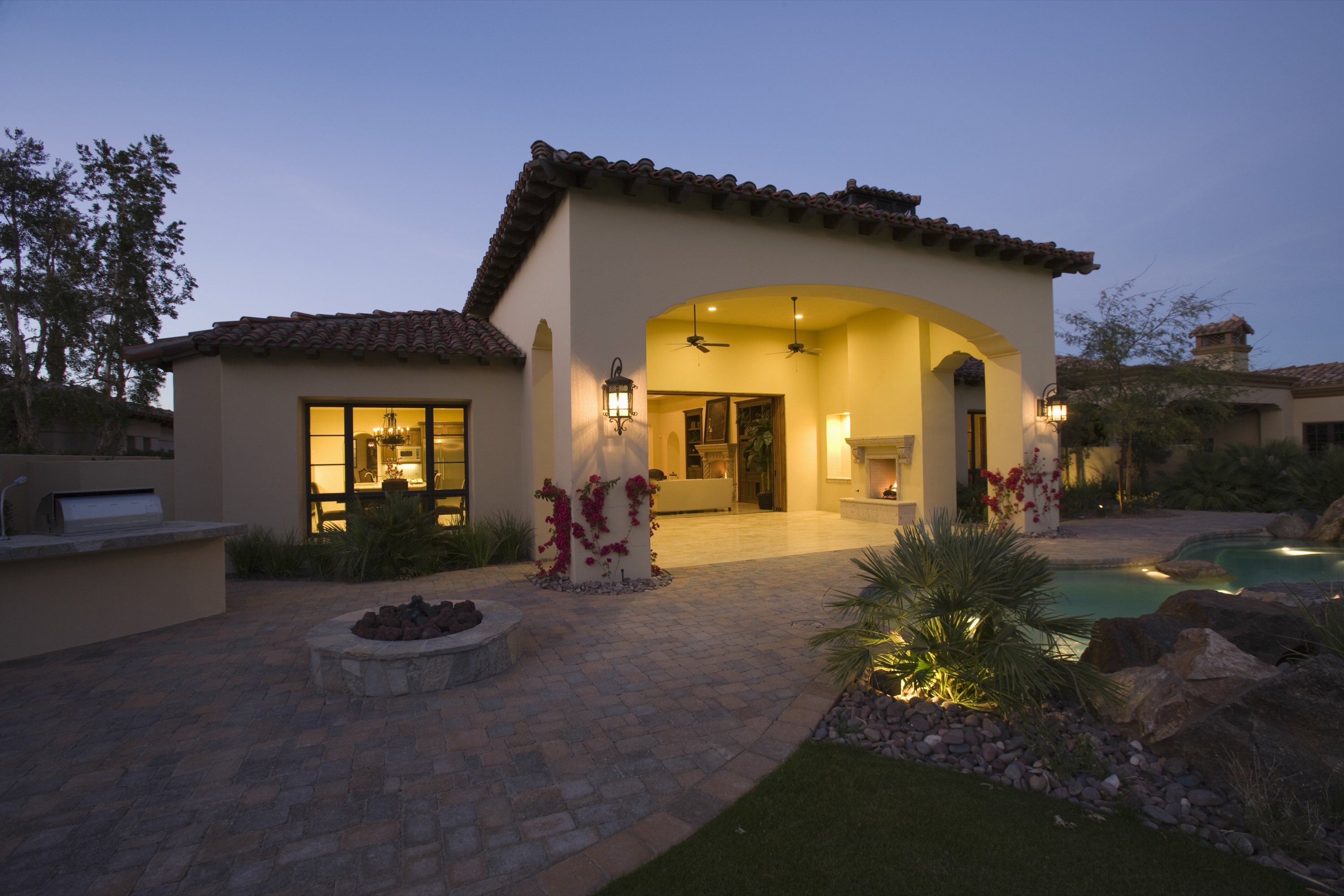 A Mediterranean-style luxury home glowing at twilight